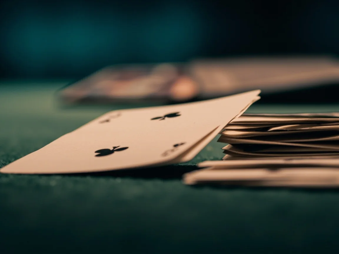 Close-up of cards fanned out for analysis with a magnifying glass and paper notes.
